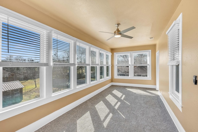 unfurnished sunroom featuring ceiling fan