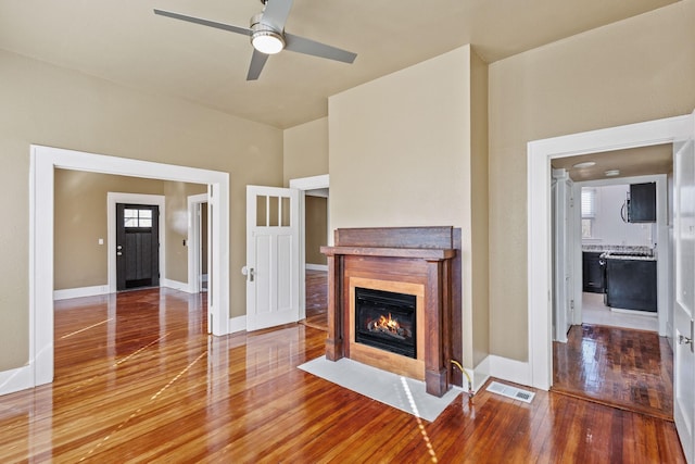 unfurnished living room with ceiling fan and hardwood / wood-style floors