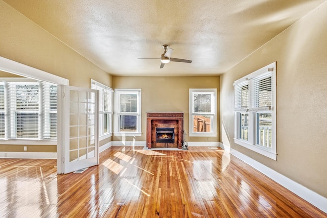 unfurnished living room featuring ceiling fan, a textured ceiling, and light wood-type flooring