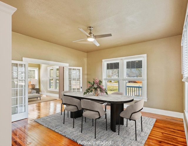 dining space featuring hardwood / wood-style flooring, a textured ceiling, french doors, and a wealth of natural light