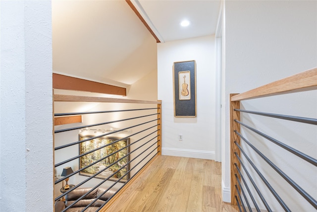 hallway featuring lofted ceiling and hardwood / wood-style flooring