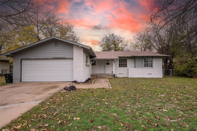 single story home featuring a lawn and a garage