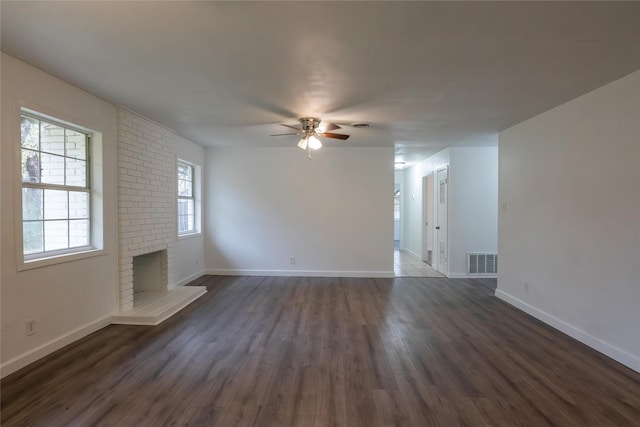 unfurnished living room featuring dark hardwood / wood-style floors, a brick fireplace, and ceiling fan