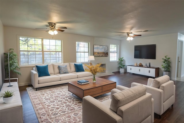 living room with ceiling fan, dark hardwood / wood-style floors, and a brick fireplace