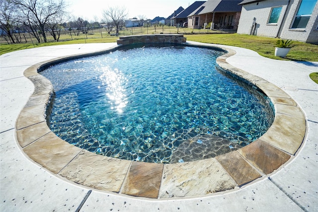 view of pool with pool water feature and a yard