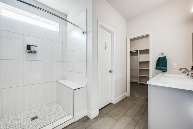 bathroom featuring tiled shower and vanity