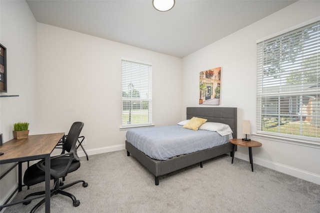 bedroom with light colored carpet and multiple windows