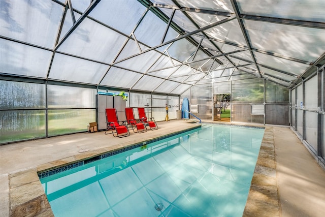 view of pool with a patio and glass enclosure