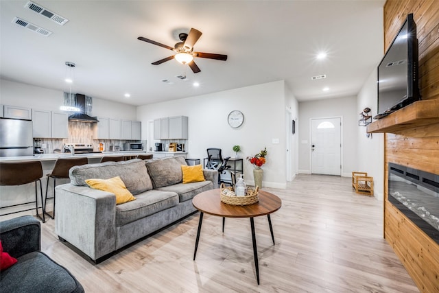 living room featuring light hardwood / wood-style floors, ceiling fan, and sink