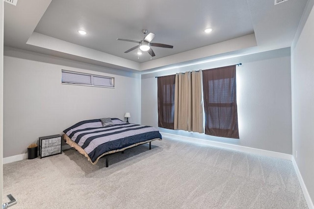 bedroom with ceiling fan, carpet, and a tray ceiling