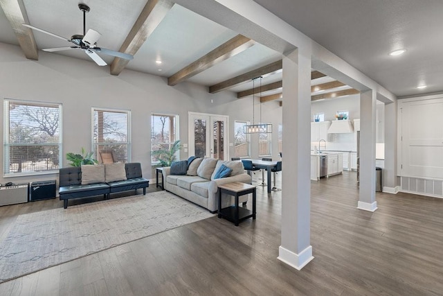 living room featuring hardwood / wood-style flooring, sink, beam ceiling, and ceiling fan