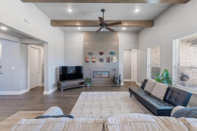 living room featuring a large fireplace, ceiling fan, beamed ceiling, and dark wood-type flooring