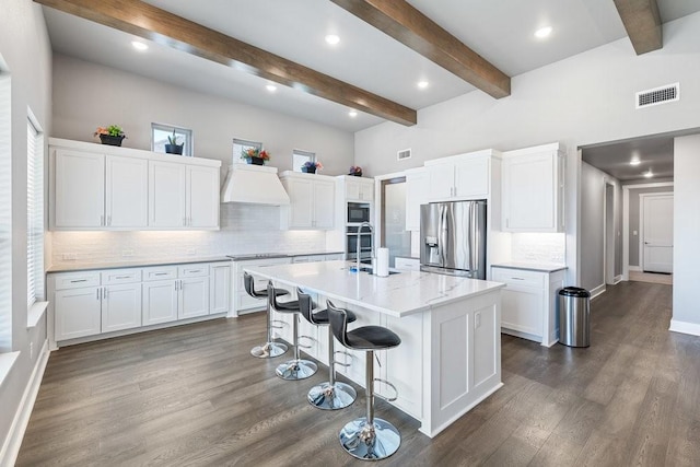 kitchen with white cabinets, black appliances, a kitchen bar, tasteful backsplash, and a kitchen island with sink