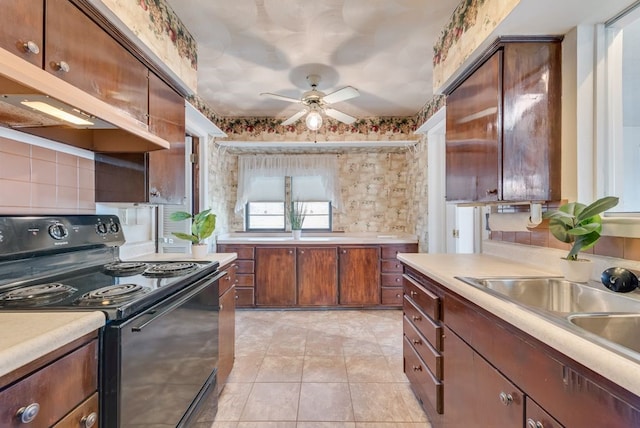 kitchen with black electric range oven, sink, ceiling fan, light tile patterned floors, and extractor fan