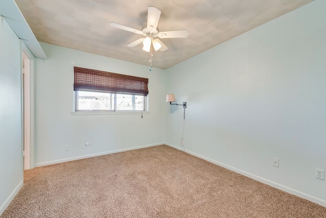 spare room with ceiling fan and carpet