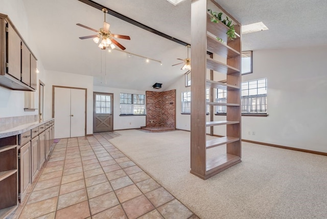 unfurnished living room with vaulted ceiling with beams, light carpet, ceiling fan, and a textured ceiling