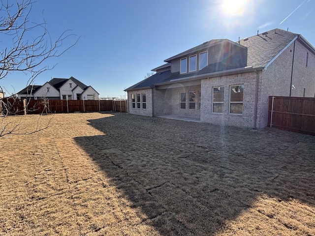 rear view of property featuring a lawn