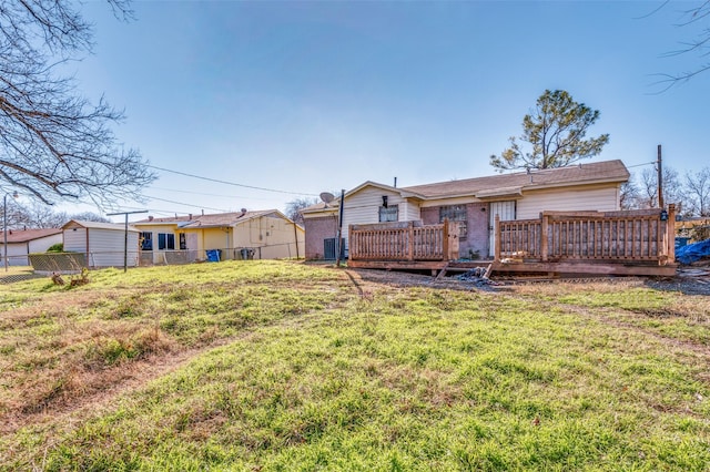 back of property with a yard, cooling unit, and a deck