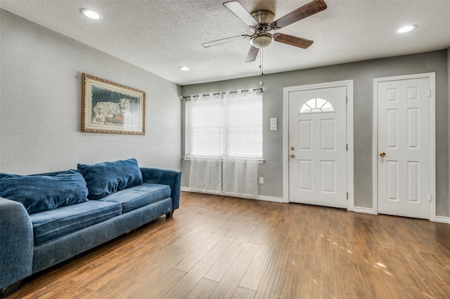 entrance foyer featuring ceiling fan, wood-type flooring, a textured ceiling, and a wealth of natural light