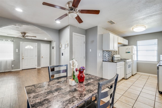 dining area with ceiling fan, light tile patterned floors, and a textured ceiling