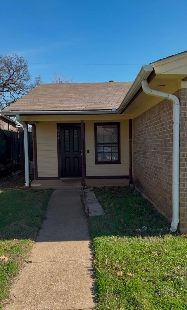 view of exterior entry with a yard