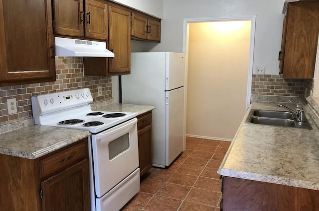 kitchen featuring backsplash, sink, and white appliances