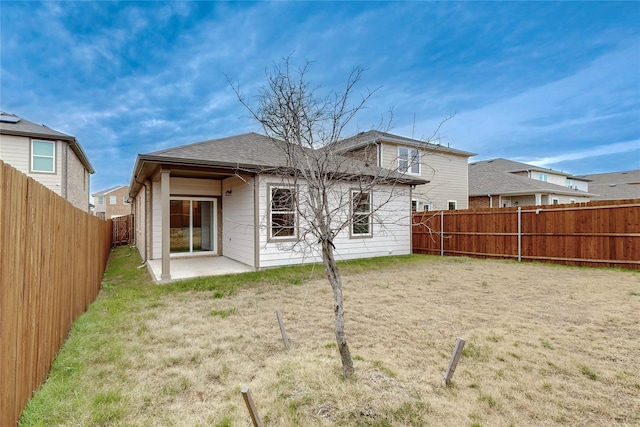 rear view of house featuring a yard and a patio