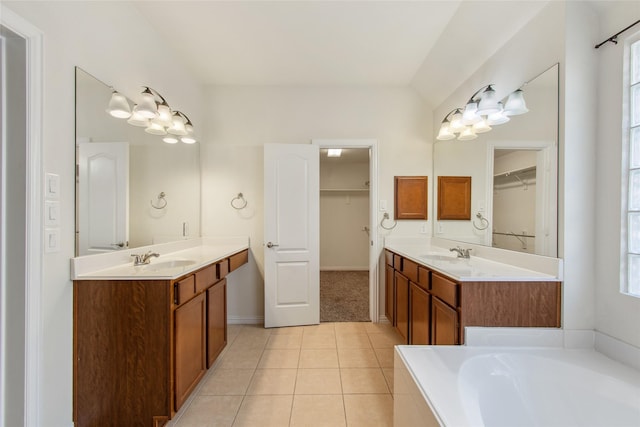 bathroom featuring tile patterned floors, a bathing tub, vanity, and a healthy amount of sunlight