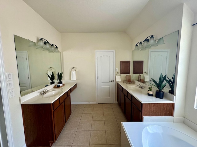 bathroom featuring tile patterned flooring, vanity, vaulted ceiling, and a tub