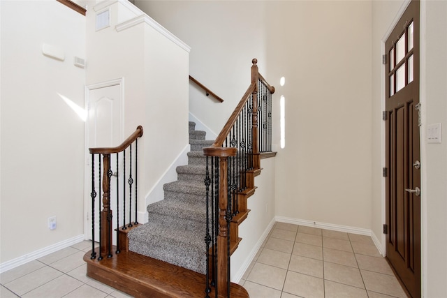 foyer entrance with light tile patterned floors and ornamental molding