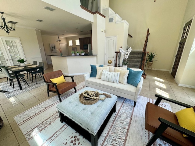 living room with light tile patterned floors, a notable chandelier, and a high ceiling