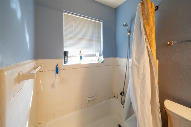 bathroom featuring toilet and shower / tub combo with curtain