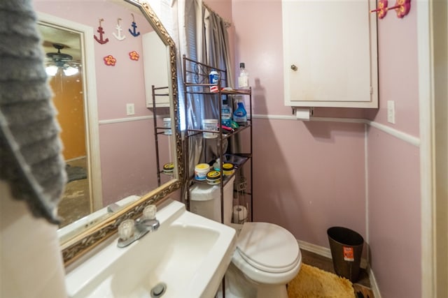 bathroom with ceiling fan, toilet, and sink