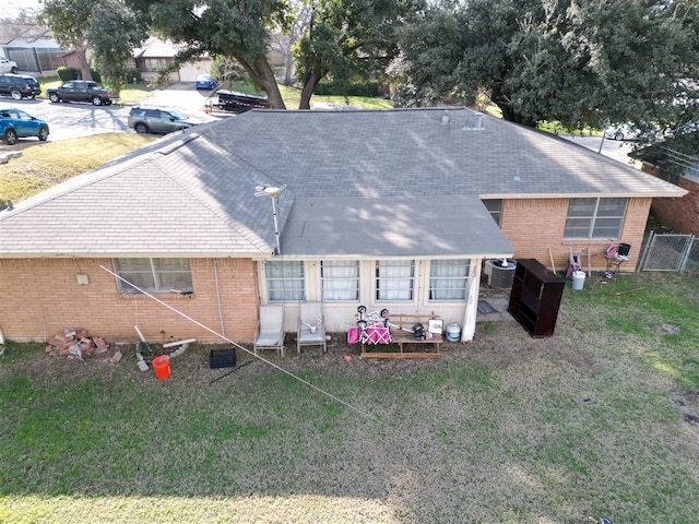 rear view of property featuring central AC unit and a yard