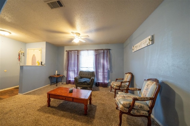 living room featuring ceiling fan, carpet floors, and a textured ceiling