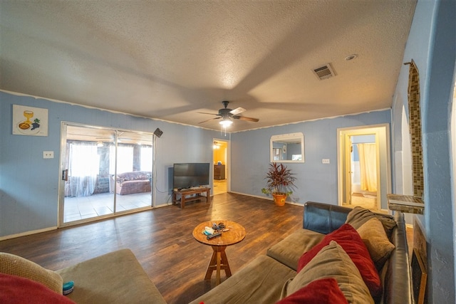 living room with dark hardwood / wood-style floors, ceiling fan, and a textured ceiling