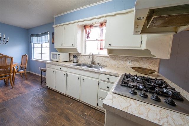 kitchen featuring sink, white cabinets, range hood, and stainless steel gas cooktop