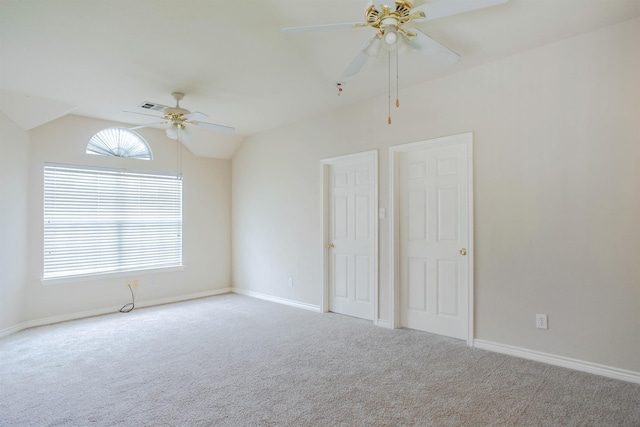 empty room with ceiling fan, light colored carpet, and vaulted ceiling