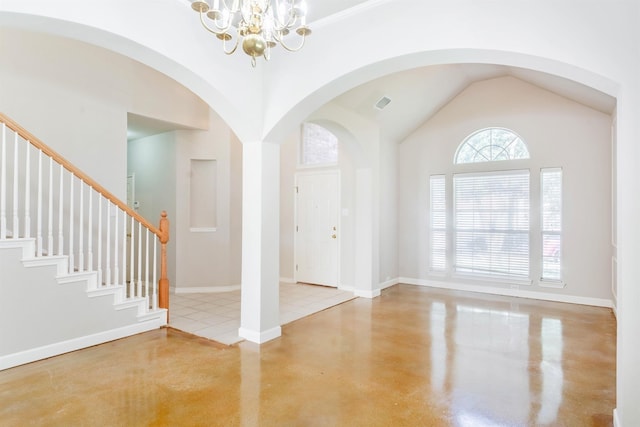 tiled entrance foyer featuring high vaulted ceiling and a notable chandelier