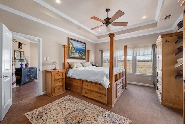 bedroom featuring a raised ceiling, ceiling fan, dark colored carpet, and ornamental molding