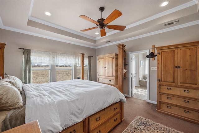 carpeted bedroom featuring ensuite bathroom, a raised ceiling, ceiling fan, and crown molding