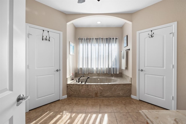 bathroom featuring a tub to relax in, tile patterned floors, and ceiling fan