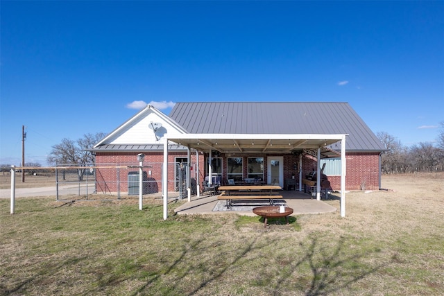 back of house with a patio and a lawn