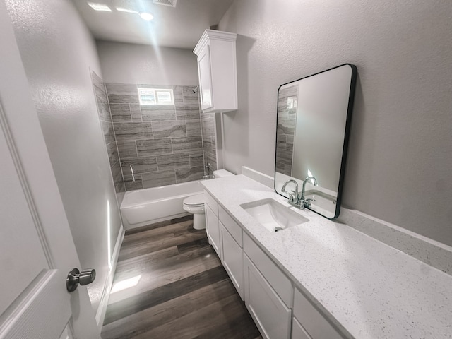 full bathroom with wood-type flooring, vanity, toilet, and tiled shower / bath