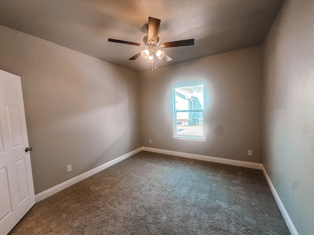 carpeted spare room featuring ceiling fan and a textured ceiling