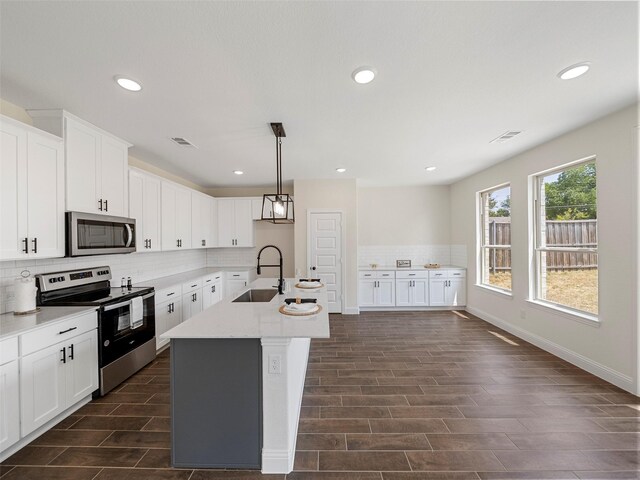 kitchen with stainless steel appliances, white cabinets, and sink