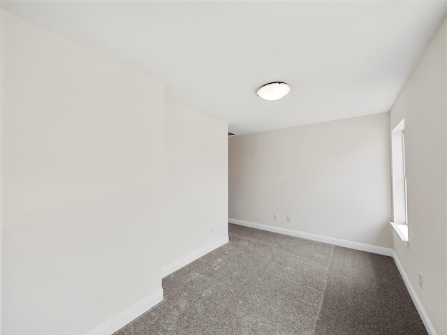 carpeted spare room featuring baseboards