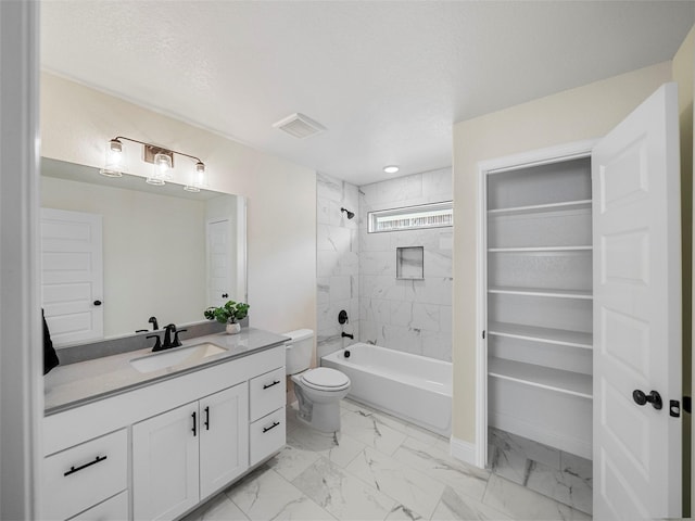 full bathroom with toilet, a textured ceiling, tiled shower / bath, and vanity