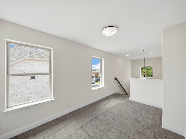 carpeted empty room featuring baseboards