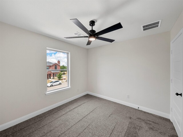 carpeted empty room with ceiling fan and a tray ceiling